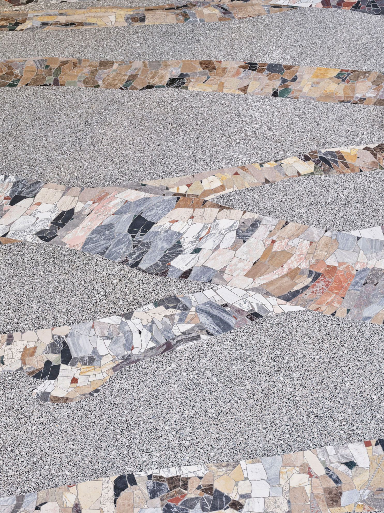 Terrazzogulv med mosaik af forskellige natursten og marmor lagt i organiske former.