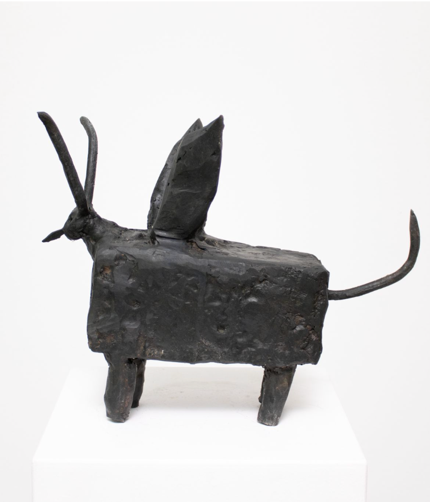 Bronze sculpture of a stylised four-legged creature with horns, wings, and a long curved tail.
