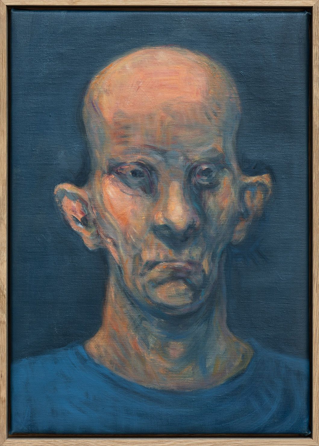 Portræt af skaldet mand med forvrængede ansigtstræk på mørk baggrund.